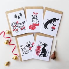 four handmade christmas cards on top of a table with red ribbon and gold ornaments