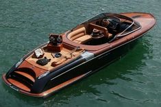 a small motor boat floating on top of a body of water with an open cockpit