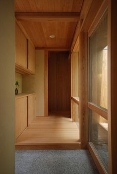 an empty room with wood paneling and glass doors leading to another room in the background