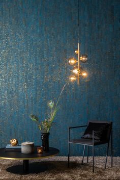 a living room with blue wallpaper and a black chair next to a coffee table