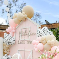 there is a pink barn with balloons all over it