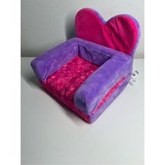 a pink and purple heart shaped chair sitting on top of a table