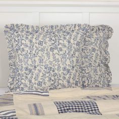 a bed with blue and white pillows on top of it