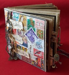 an open book with stamps and chains on the front, sitting on a red surface