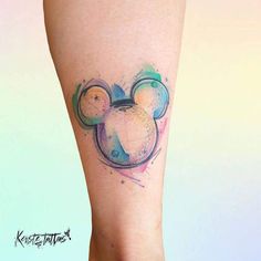 a watercolor mickey mouse tattoo on the right leg and calf's lower arm