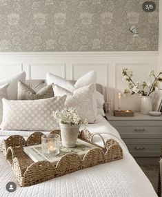 a tray with flowers on top of a bed next to a night stand and nightstand