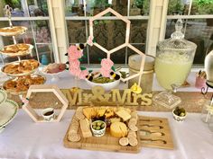 a table topped with lots of food next to a glass vase filled with milk and other items