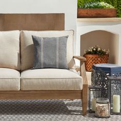 a couch sitting on top of a rug next to a table with candles and vases