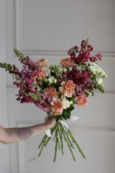 a person holding a bouquet of flowers in their hand