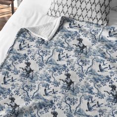 a bed with blue and white comforters on top of it