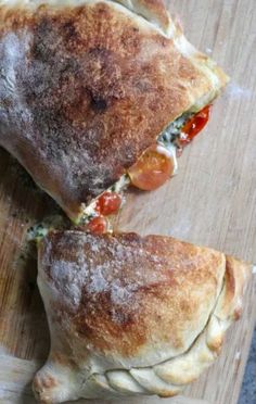 two pieces of pizza sitting on top of a wooden cutting board