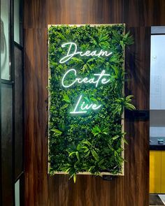 a sign that says dream create live on the side of a wall covered in plants