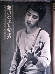 an old photo of a young man playing a guitar