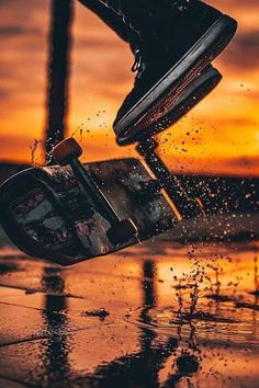 a skateboarder is doing a trick in the air over water at sunset or sunrise