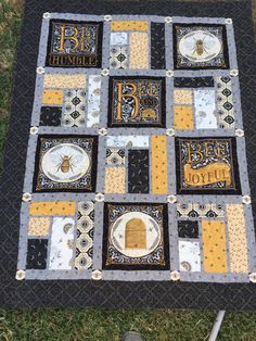 a black and yellow quilt on the grass