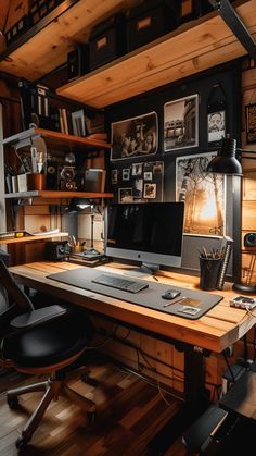 a desk with a computer on top of it in a room filled with books and pictures