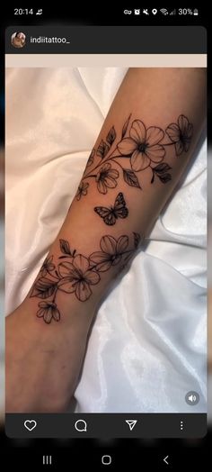 a woman's arm with flowers and butterflies on it