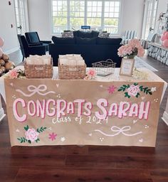 a table with congratulations signs on it in the middle of a room filled with balloons