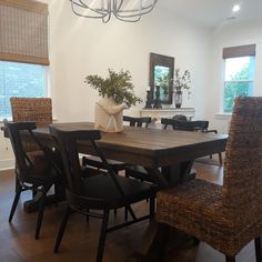 a dining room table with chairs and a vase on it