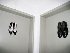 two pairs of shoes are hanging on the wall