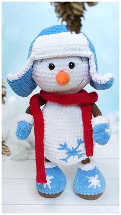 a crocheted snowman with a red scarf and hat