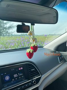 the interior of a car with two strawberries hanging from it's dash board