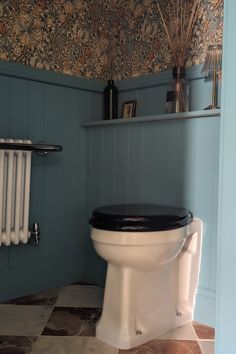 a white toilet sitting in a bathroom next to a radiator