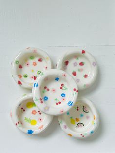 five small dishes with colorful designs on them