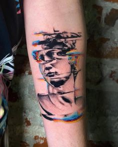 a person with a tattoo on their arm that has an image of a man's face