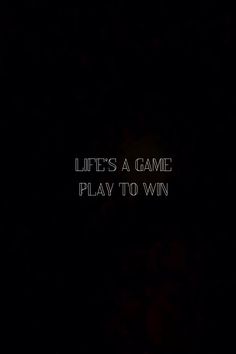 the words life's a game play to win are lit up in the dark