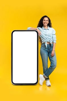 a woman standing next to a large white sign on a yellow background with her arms behind her back