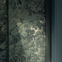 the wall paper in this room is very intricately decorated with trees and foliages