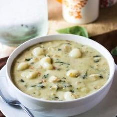 a white bowl filled with soup on top of a plate