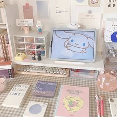 an assortment of stationery items are displayed on a table with a computer and books