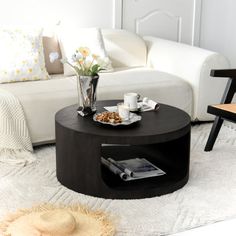 a living room filled with furniture and a coffee table in front of a white couch