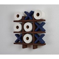 several rolls of toilet paper are arranged on a wooden shelf in front of a white wall