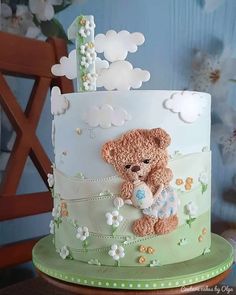 a teddy bear cake with flowers and clouds on it