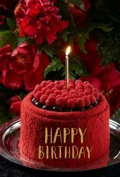 a red birthday cake with a lit candle on it