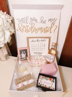 a white box filled with personalized items on top of a table next to a sign