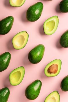 avocado cut in half on pink background