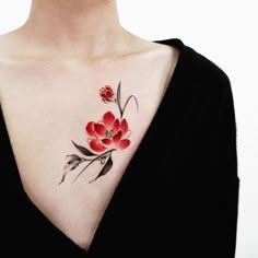 a woman's chest with red flowers on her left side and black leaves on the right side