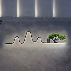 a bonsai tree is displayed in front of a wall with an equal wave on it