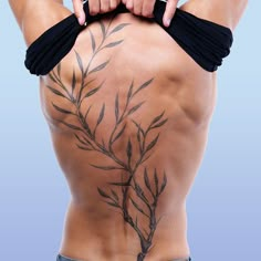 the back of a man's body with tattoos on his lower and lower back