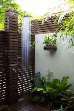 an image of a shower in the middle of a garden with plants growing out of it