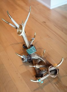 three deer antlers are sitting on the floor with beads and rings in their mouths