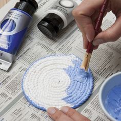 a person is painting the inside of a paper with blue and white paint on it