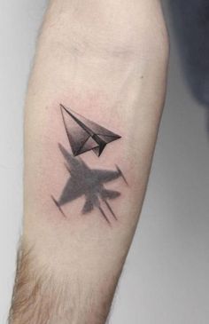 a man's arm with an origami paper airplane tattoo on the left forearm