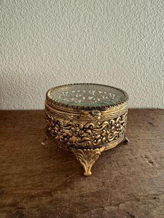 an ornate brass box sitting on top of a wooden table