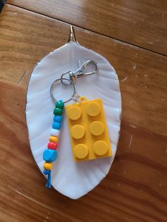 a lego keychain is sitting on a paper plate with a lego block attached to it