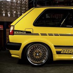 a yellow car parked in a garage next to boxes